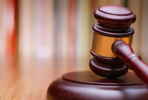 Close up Shiny Wooden Law Gavel in Dark Brown Color, on Top of Wooden Table at the Office.